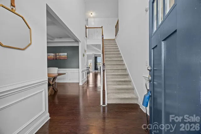 a view of a hallway with wooden floor and stairs