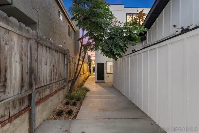 a path view of a house with a tree
