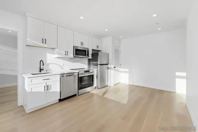 a kitchen with white cabinets stainless steel appliances and sink