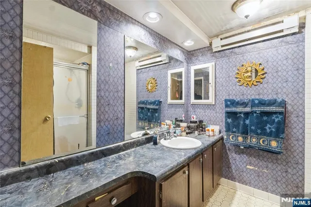 a bathroom with a granite countertop sink and a mirror