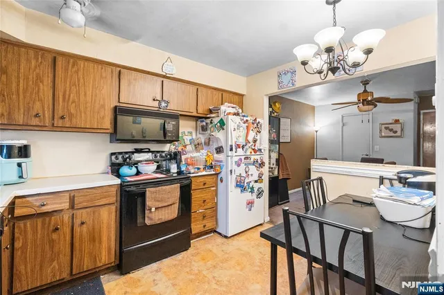 a kitchen with stainless steel appliances granite countertop a refrigerator a stove top oven a sink dishwasher and white cabinets with wooden floor