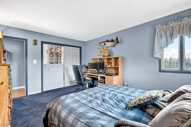 a bedroom with a bed and a flat tv screen on dresser