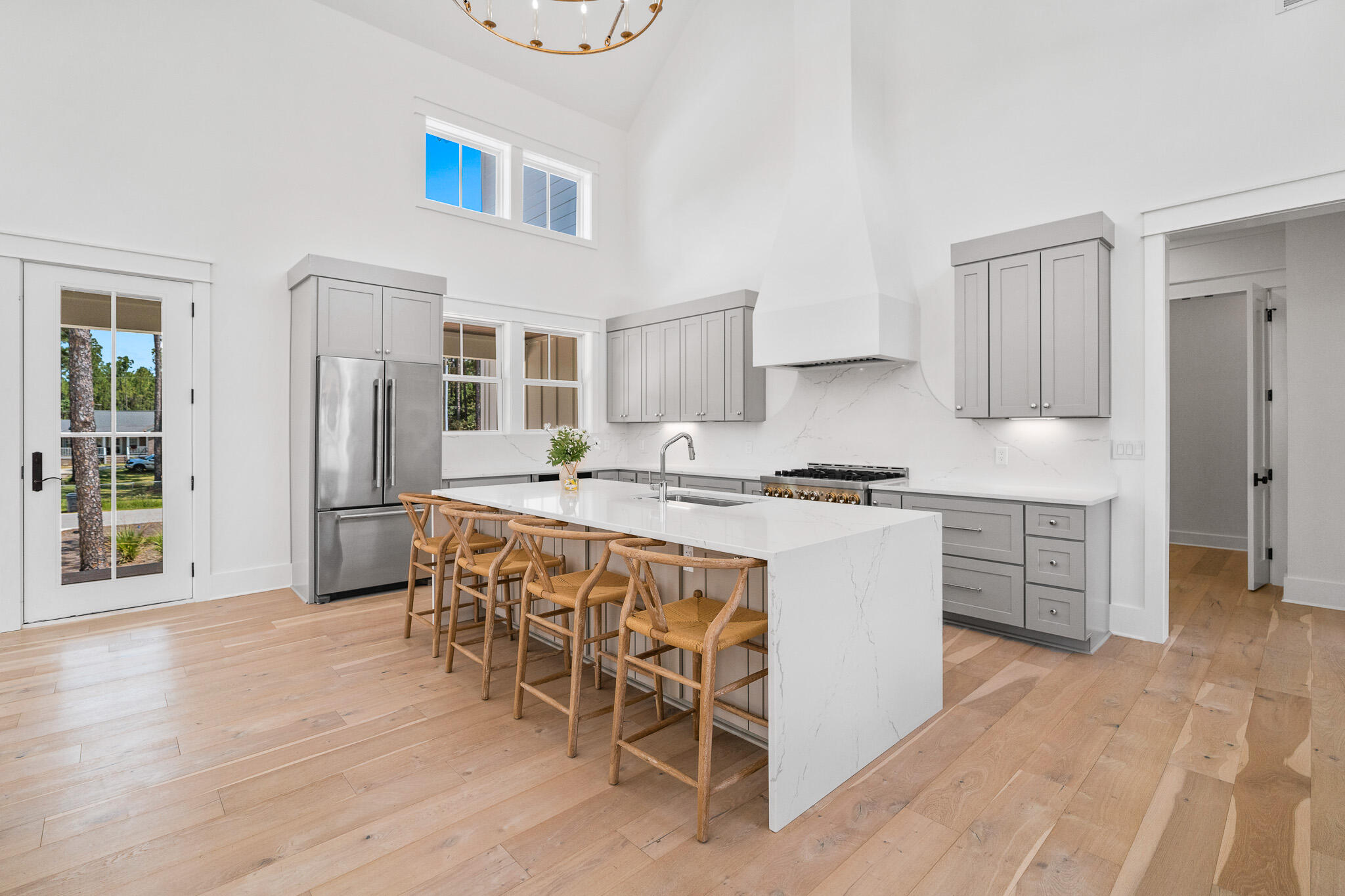 121 West Nursery Road Santa Rosa Beach, FL 32459 - Photo 30 of 66 a kitchen with stainless steel appliances granite countertop a refrigerator a stove a sink and white cabinets with wooden floor