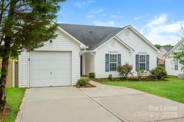 a front view of a house with a garden and yard