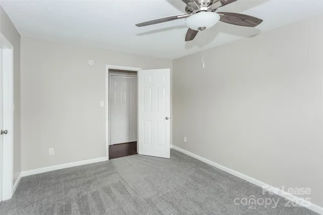 a view of an empty room with a ceiling fan