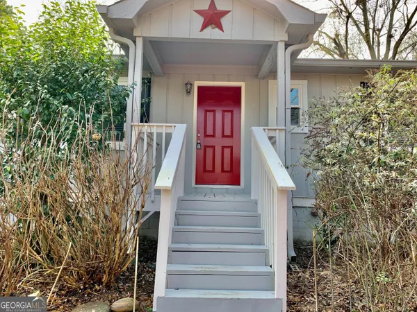 a front view of a house with a tree