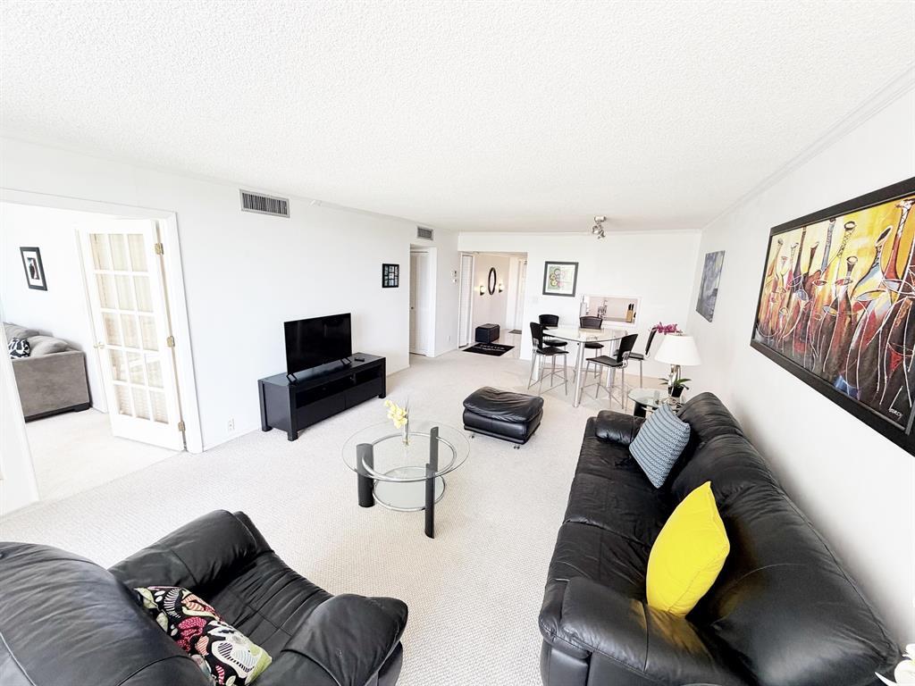 2681 South Course Drive, Unit 511 Pompano Beach, FL 33069 - Photo 11 of 35 a living room with furniture and a flat screen tv