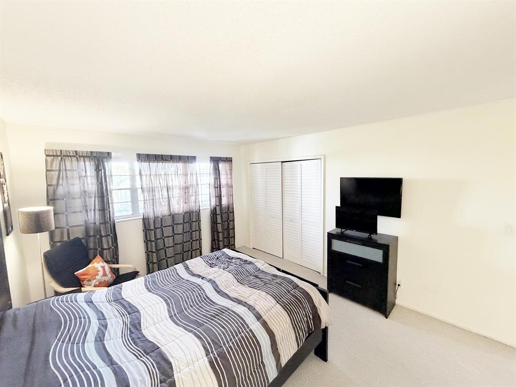 2681 South Course Drive, Unit 511 Pompano Beach, FL 33069 - Photo 17 of 35 a bedroom with a bed and a television