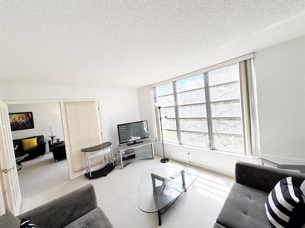 2681 South Course Drive, Unit 511 Pompano Beach, FL 33069 - Photo 23 of 35 a living room with furniture and a flat screen tv