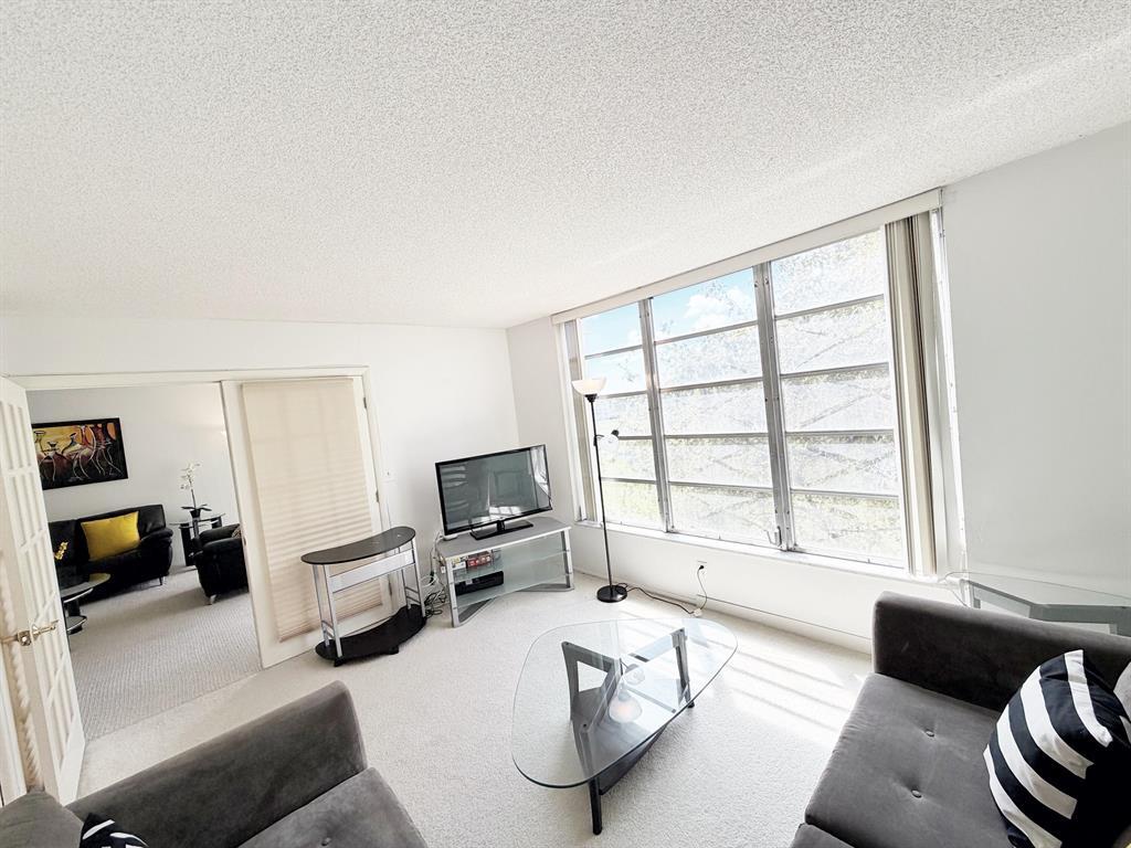 2681 South Course Drive, Unit 511 Pompano Beach, FL 33069 - Photo 24 of 35 a living room with furniture and a flat screen tv