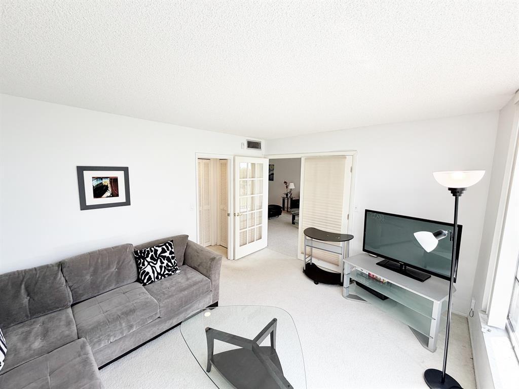 2681 South Course Drive, Unit 511 Pompano Beach, FL 33069 - Photo 25 of 35 a living room with furniture and a flat screen tv