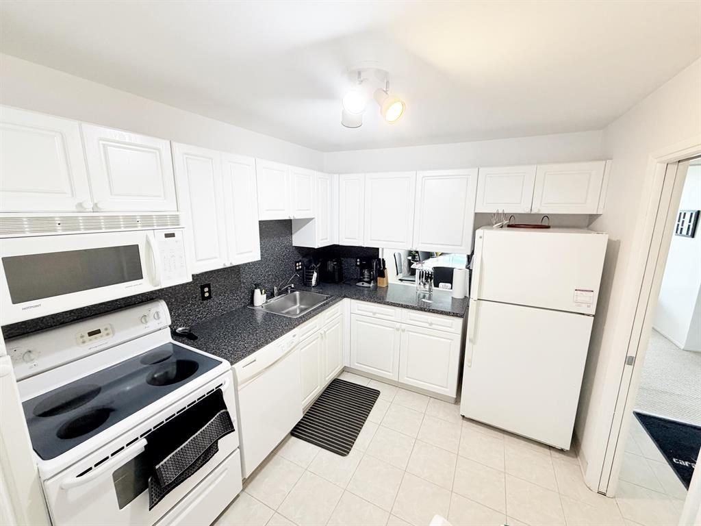 2681 South Course Drive, Unit 511 Pompano Beach, FL 33069 - Photo 6 of 35 a kitchen with a refrigerator and a stove top oven