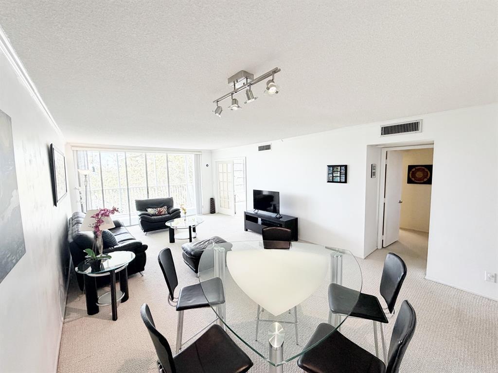 2681 South Course Drive, Unit 511 Pompano Beach, FL 33069 - Photo 9 of 35 a living room with furniture a flat screen tv and a window