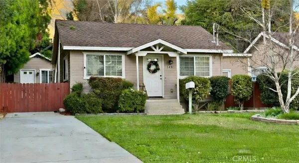 a front view of a house with a yard and plants