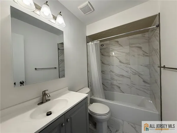 a bathroom with a sink mirror toilet and bathtub