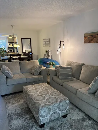 a living room with furniture and a chandelier