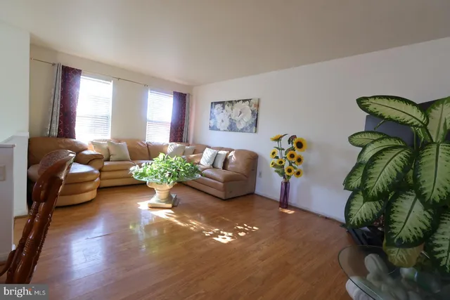 a living room with furniture flowers and a potted plant