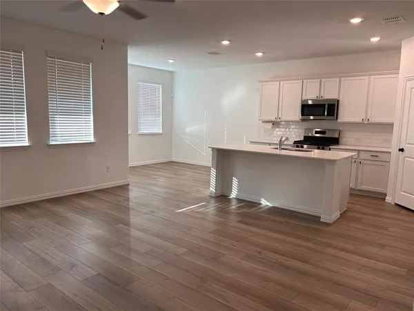 a kitchen with stainless steel appliances granite countertop a sink a stove top oven a counter space and cabinets