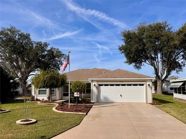 a view of a house with backyard and a tree