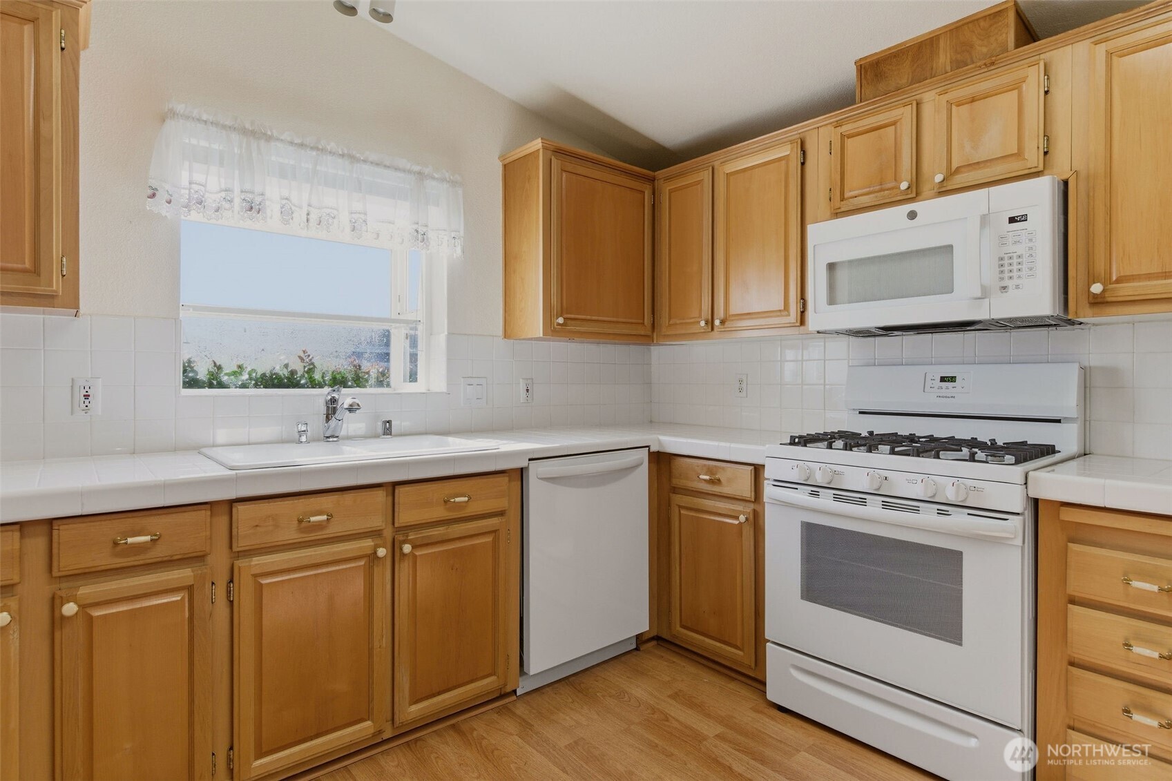 24036 222nd Avenue Southeast Maple Valley, WA 98038 - Photo 9 of 37 a kitchen with white cabinets and white appliances