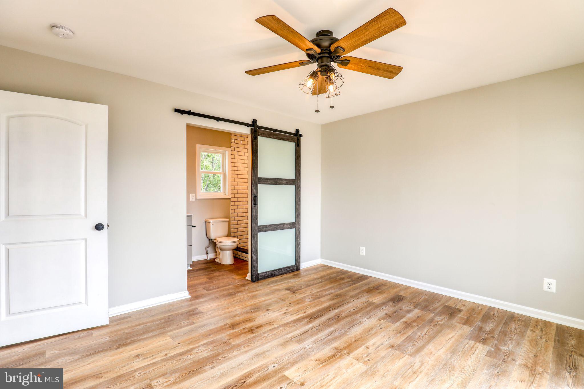 0 Gooney Manor Loop Bentonville, VA 22610 - Photo 11 of 17 a view of a big room with wooden floor and a chandelier fan