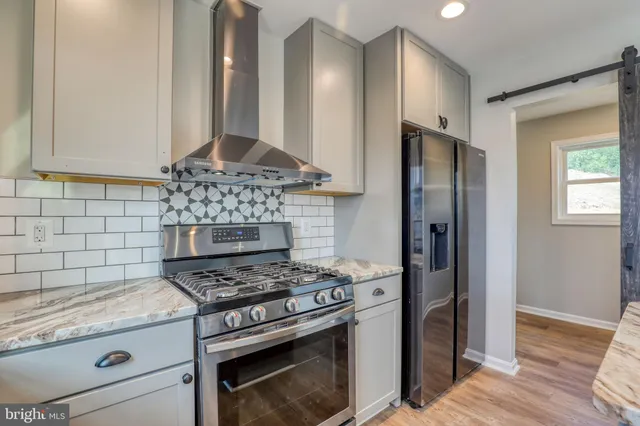 a kitchen with stainless steel appliances granite countertop a stove and a refrigerator