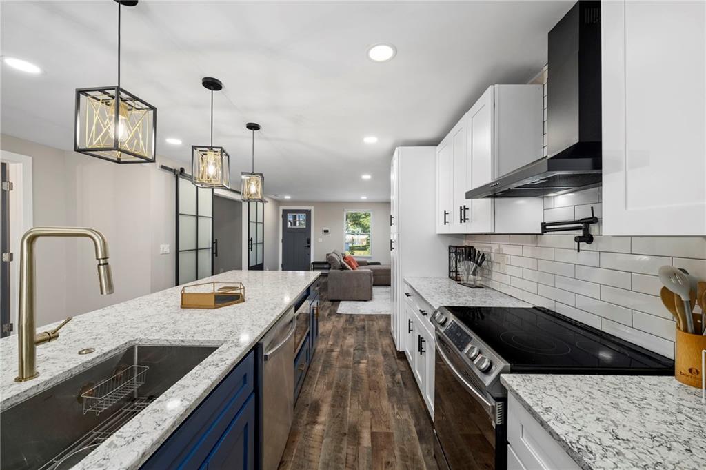 298 Roy Street Southwest Atlanta, GA 30310 - Photo 12 of 50 a kitchen with stainless steel appliances granite countertop a sink stove and refrigerator