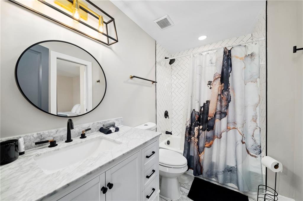298 Roy Street Southwest Atlanta, GA 30310 - Photo 22 of 50 a bathroom with a granite countertop sink a toilet and a mirror