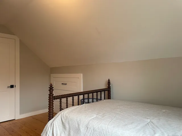 a bed sitting in a bedroom next to a window