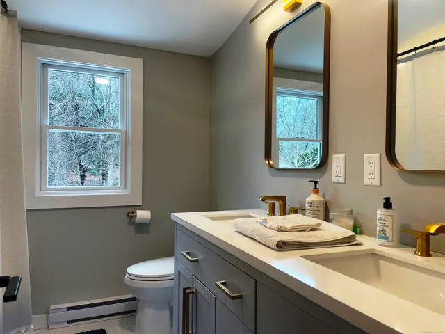 a bathroom with a sink toilet and a mirror