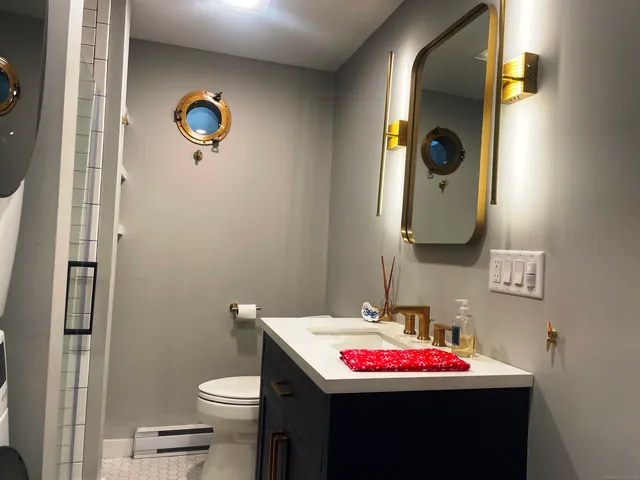 a bathroom with a sink and mirror with toilet