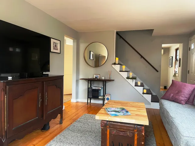 a living room with furniture a flat screen tv and kitchen view