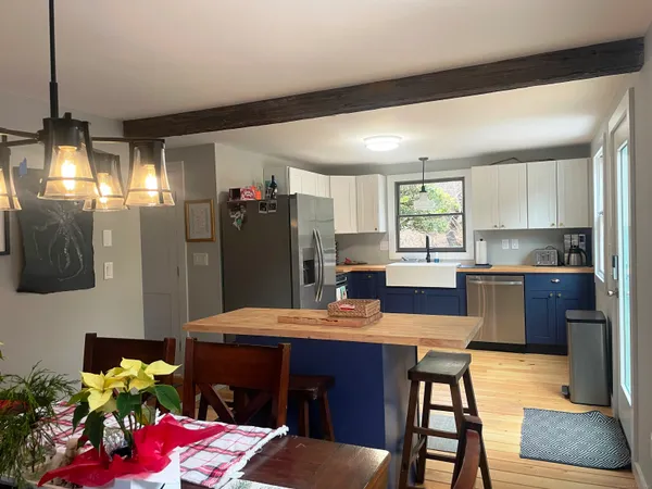 a kitchen with a refrigerator and a dining table