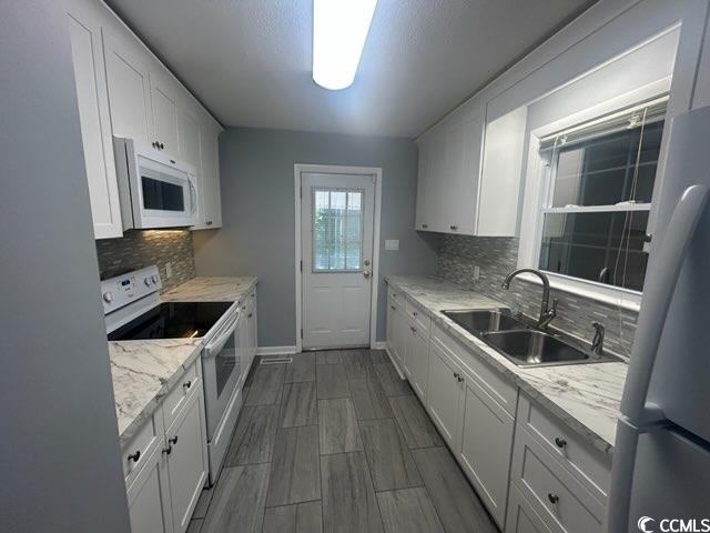 1105 Scott Drive Myrtle Beach, SC 29577 - Photo 4 of 7 Kitchen featuring backsplash, a sink, white applia