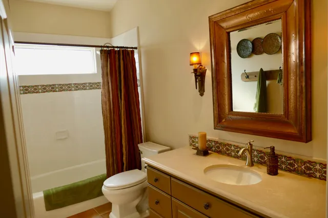 a bathroom with a granite countertop sink toilet and shower