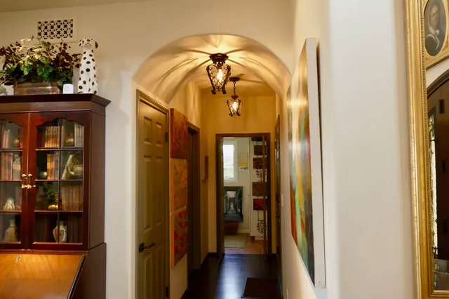 a view of a hallway with wooden floor and a dining room