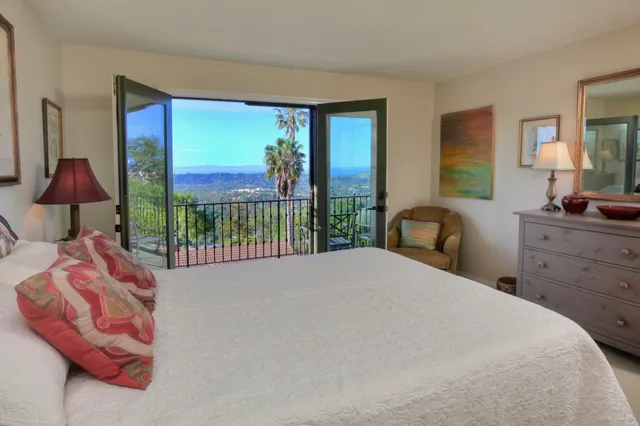 a bedroom with a bed and a large window