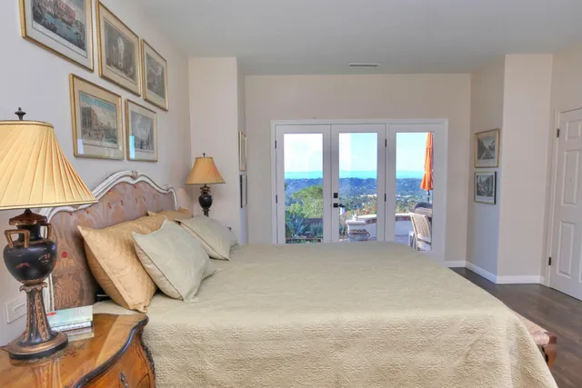 a large bedroom with a bed and large windows