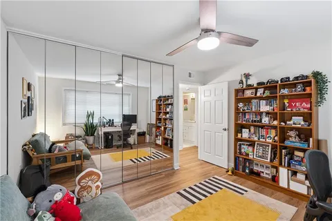 a living room with furniture a bookshelf and a window