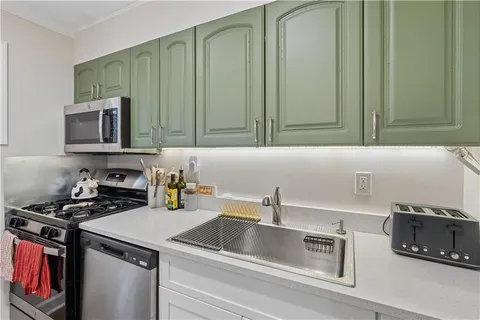 a kitchen with a sink stove top oven and cabinets