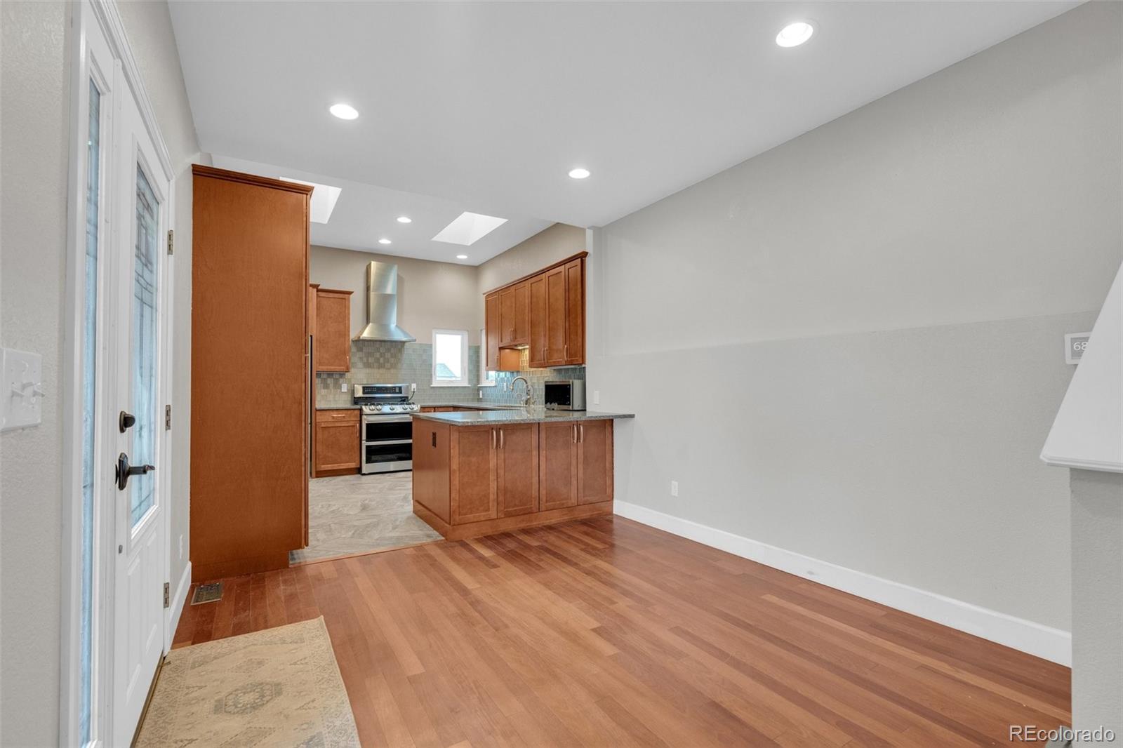 1227 Coronado Road Elizabeth, CO 80107 - Photo 14 of 45 a room with stainless steel appliances kitchen island granite countertop wooden floors and view of living room