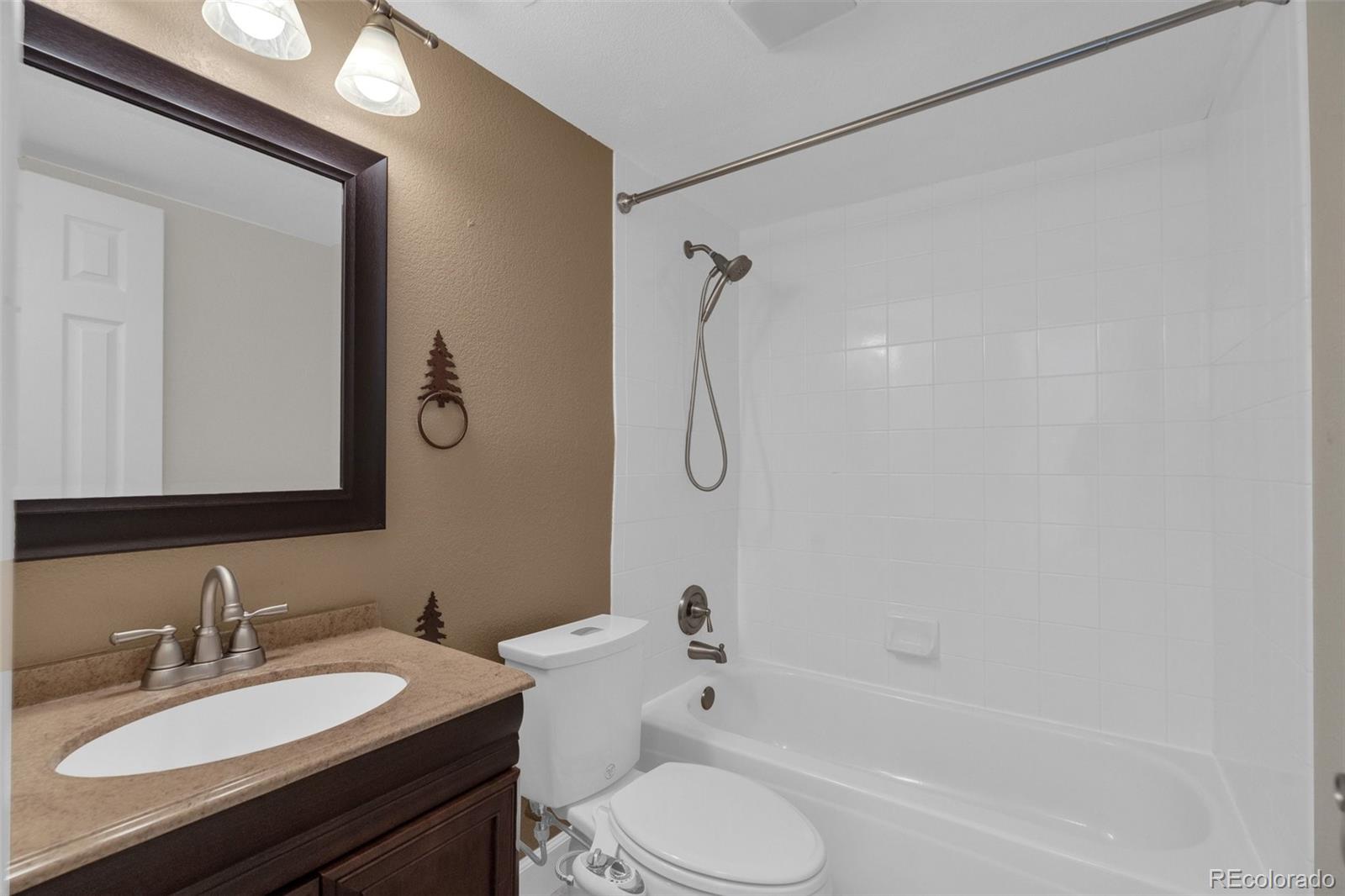 1227 Coronado Road Elizabeth, CO 80107 - Photo 24 of 45 a bathroom with a granite countertop sink toilet a mirror and shower