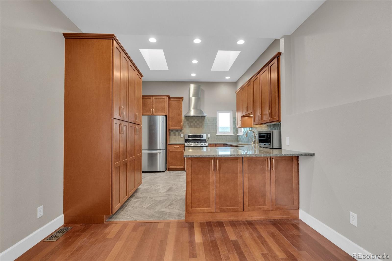 1227 Coronado Road Elizabeth, CO 80107 - Photo 6 of 45 a kitchen with stainless steel appliances granite countertop a refrigerator a sink dishwasher and a oven with wooden floors