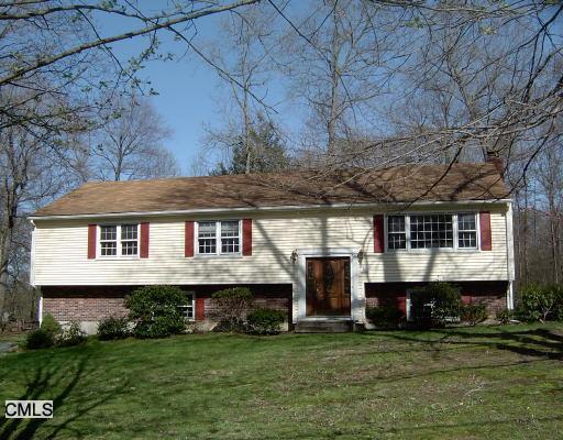 a view of a big house with a big yard and large trees