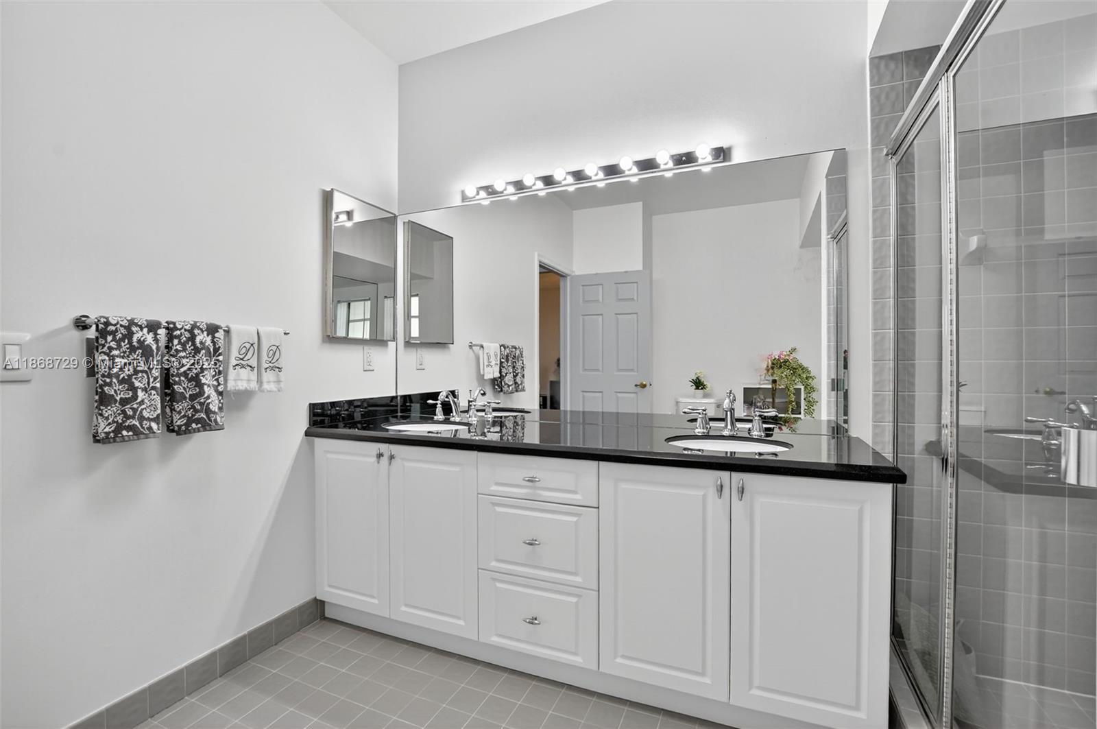 7596 Elm Ridge Drive, Unit 2U Boca Raton, FL 33433 - Photo 21 of 45 a bathroom with a granite countertop sink and a mirror