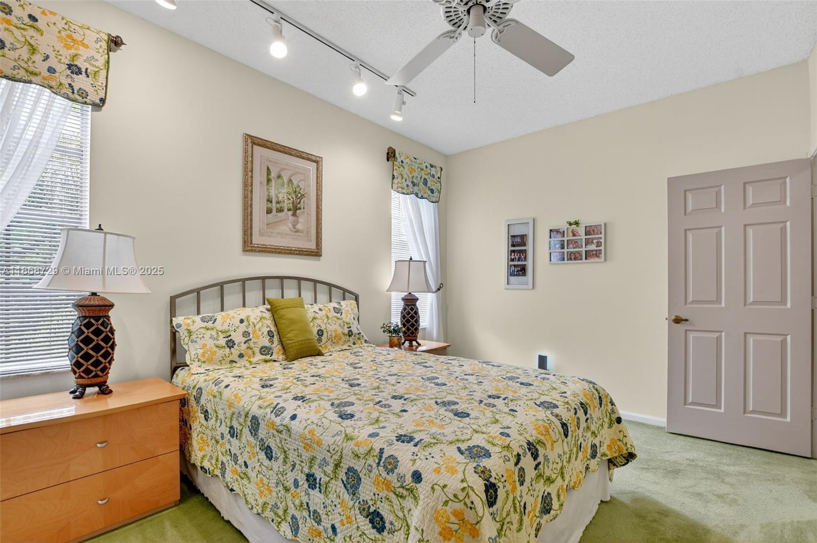 7596 Elm Ridge Drive, Unit 2U Boca Raton, FL 33433 - Photo 24 of 45 a bedroom with a large bed and a chandelier