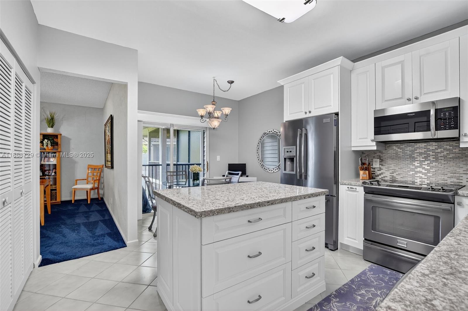 7596 Elm Ridge Drive, Unit 2U Boca Raton, FL 33433 - Photo 4 of 45 a kitchen with white cabinets and stainless steel appliances