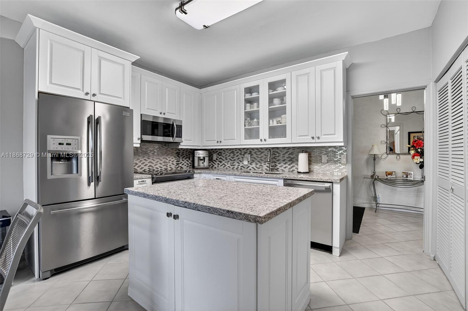 7596 Elm Ridge Drive, Unit 2U Boca Raton, FL 33433 - Photo 5 of 45 a kitchen with stainless steel appliances granite countertop a refrigerator sink and cabinets