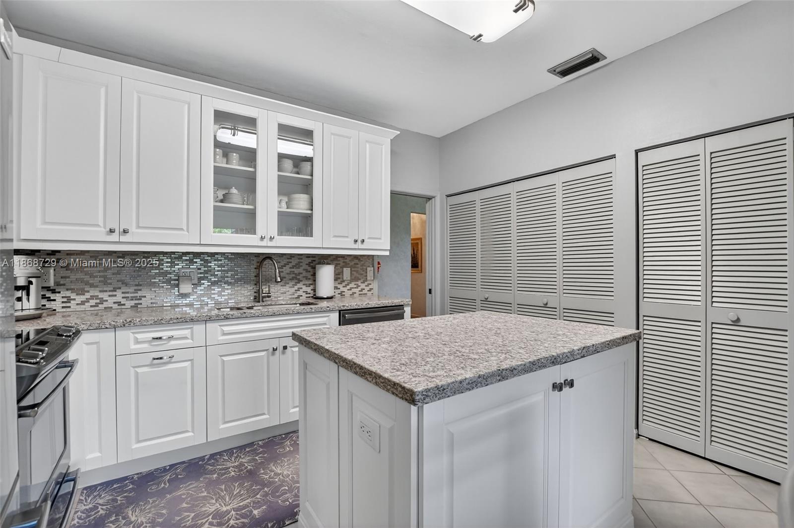 7596 Elm Ridge Drive, Unit 2U Boca Raton, FL 33433 - Photo 6 of 45 a kitchen with a sink stove and cabinets