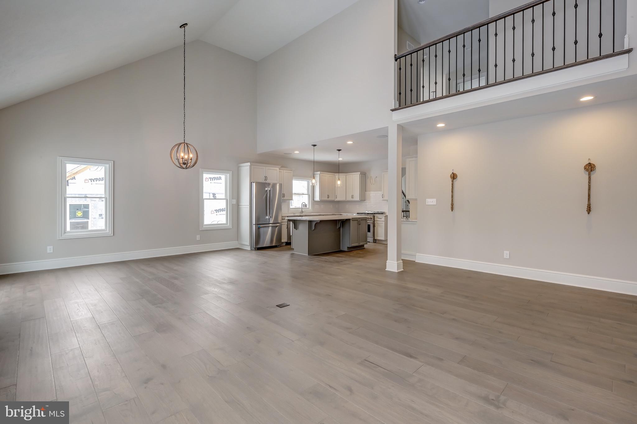 102 Harvey Road, Unit 1PS Wallingford, PA 19086 - Photo 6 of 18 an empty room with wooden floor and windows
